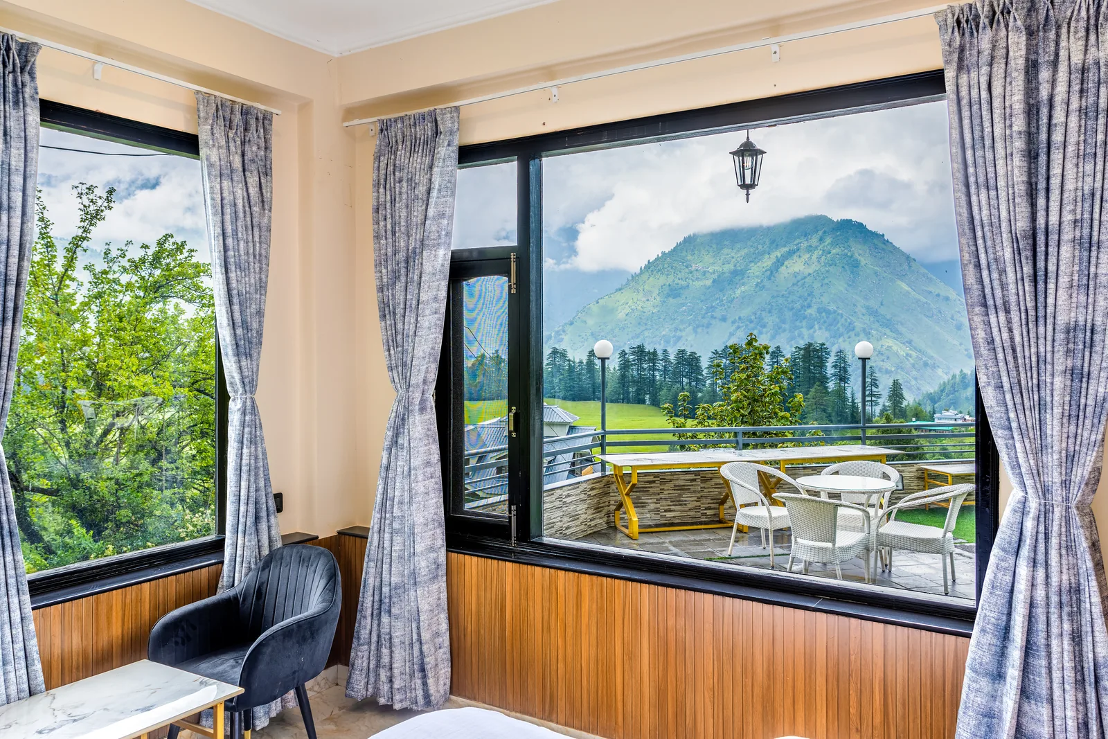 Jr. Suite — armchair at the window, deodar forest beyond