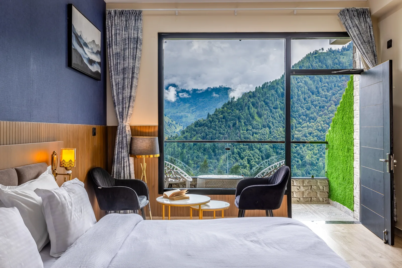Meadow Suite — king bed with the balcony door open onto the mountains